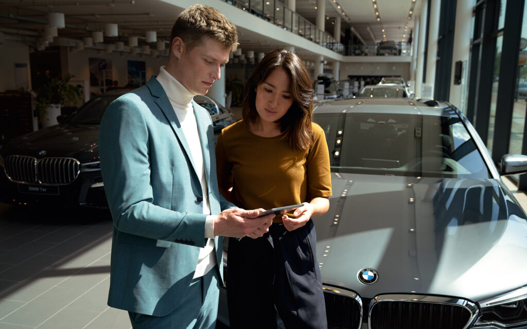 Mann und Frau im Autohaus am Tablet