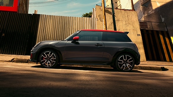 Seitenansicht eines parkenden MINI John Cooper Works in der Farbe Schwarz mit roten Sport Stripes