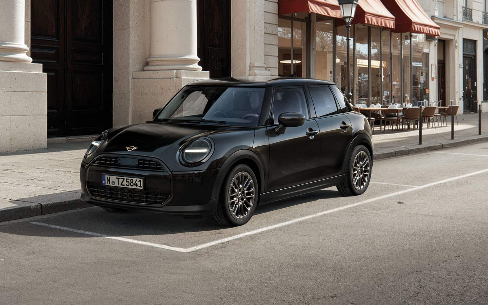 MINI Cooper 5-Türer Blackyard parkt am Straßenrand vor mondäner Stadtlandschaft