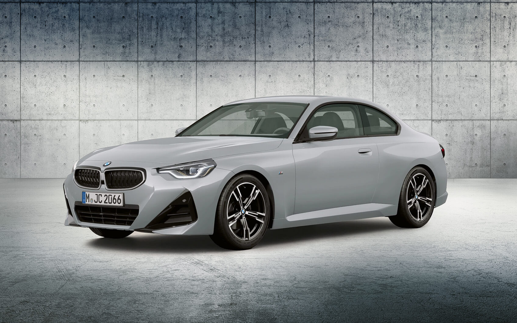 Weißes BMW 230i Coupé vor Betonwand