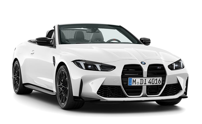 Weißes BMW M4 Competition Cabrio mit geöffnetem Verdeck und sportlicher Frontansicht vor hellem Hintergrund.
