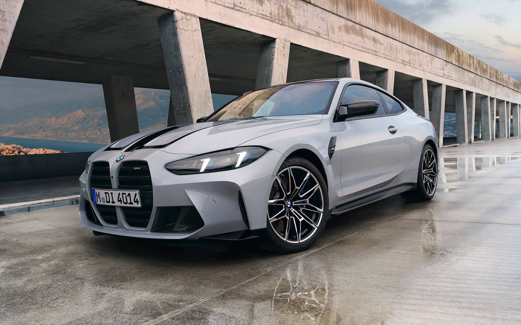 Weißes BMW M4 Coupé in Front-Seitenansicht unter Betonbrücke
